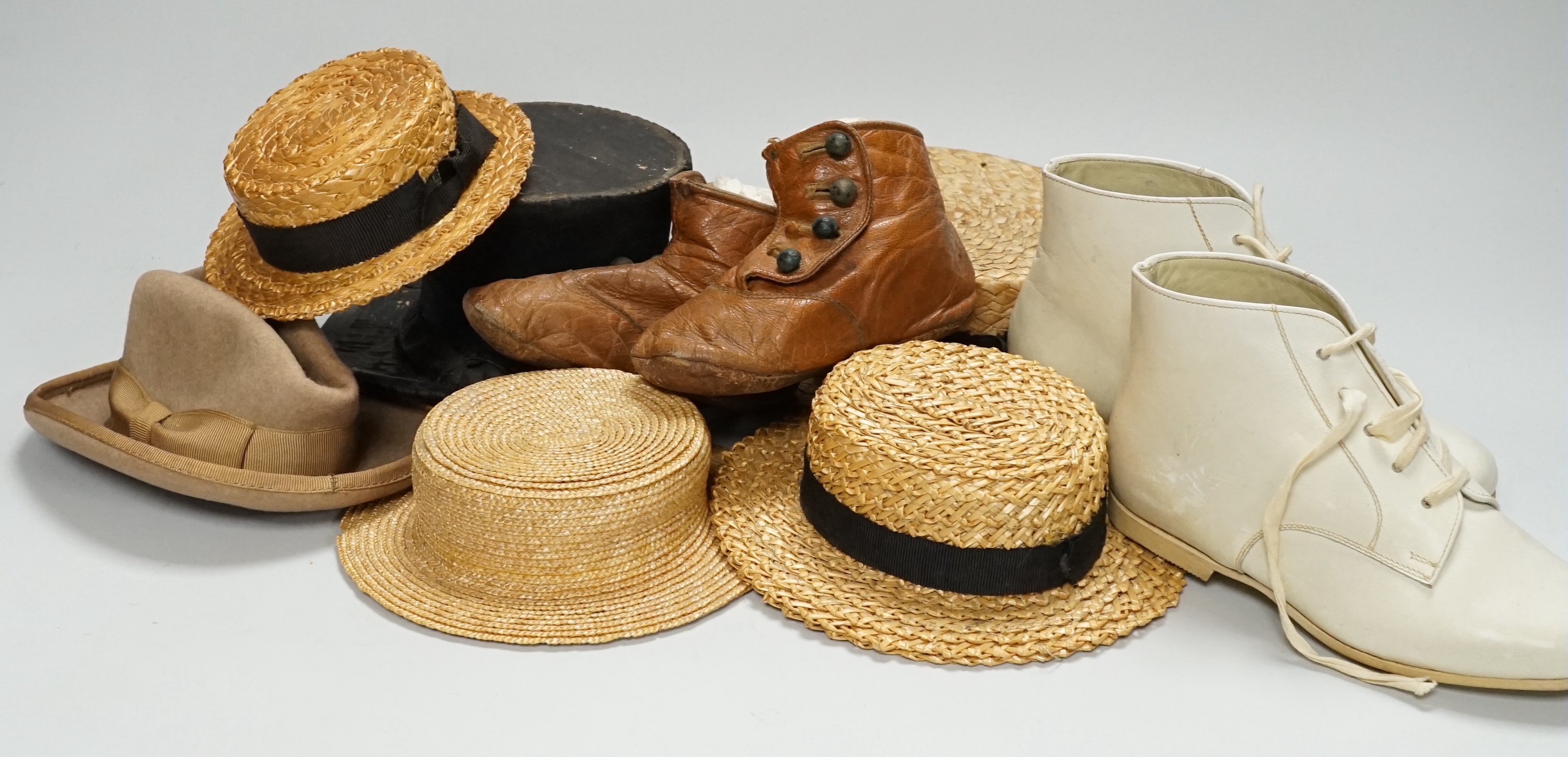 A collection of eleven bear size vintage hats, straw and felt, and a pair of miniature boxing gloves, also white books and Victorian brown leather boots, three pairs of dolls shoes and an umbrella